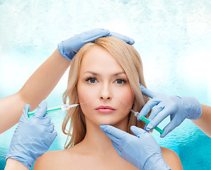 Image showing woman face and beautician hands with syringes