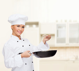 Image showing smiling female chef with pan and spoon