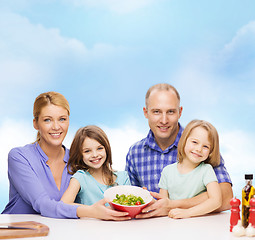 Image showing happy family with two kids with salad at home