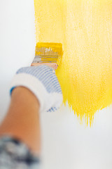 Image showing close up of male in gloves holding paintbrush