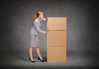 Image showing busy businesswoman pushing tower of cardboards