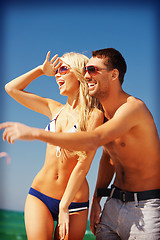 Image showing happy couple in sunglasses on the beach