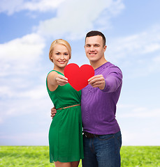 Image showing smiling couple holding big red heart