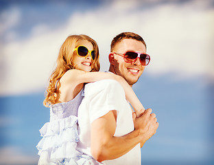 Image showing happy father and child in sunglasses over blue sky