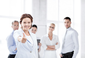 Image showing businesswoman in office showing thumbs up