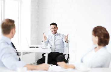 Image showing businessman showing thumbs up in office