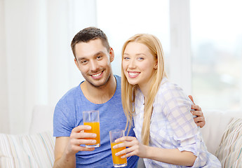 Image showing smiling happy couple at home drinking juice