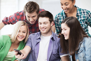 Image showing students looking into smartphone at school