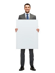Image showing smiling businessman with white blank board