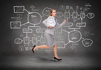 Image showing stressed young businesswoman with clock running