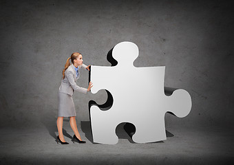 Image showing busy businesswoman pushing puzzle piece