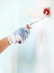 Image showing close up of male in gloves painting wall