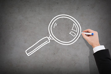 Image showing close up of businessman drawing magnifying glass