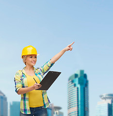 Image showing smiling woman in helmet with clipboard