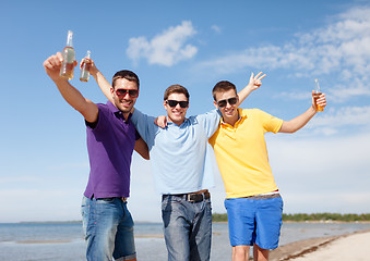 Image showing friends having fun on beach with bottles of beer