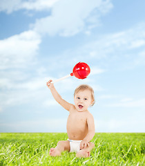 Image showing cute little boy playing with big lollipop