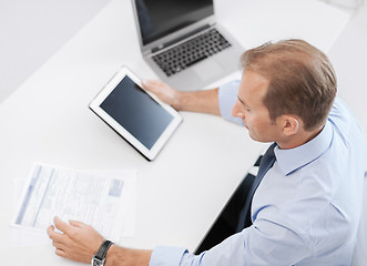 Image showing businessman with tablet pc and papers in office