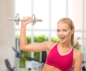 Image showing smiling woman with heavy steel dumbbell