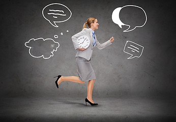 Image showing smiling young businesswoman with clock running