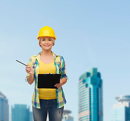 Image showing smiling woman in helmet with clipboard