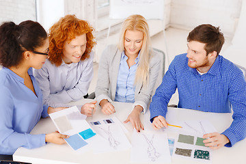 Image showing smiling creative team looking at sketch