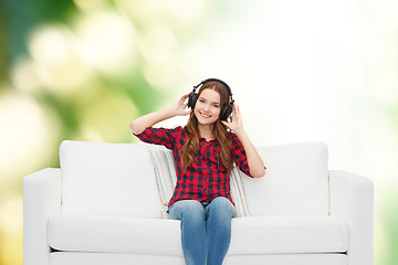 Image showing teenage girl sitting on sofa with headphones