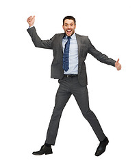 Image showing smiling businessman jumping and showing thumbs up