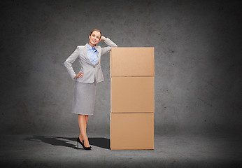 Image showing smiling businesswoman with cardboard boxes