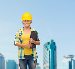 Image showing smiling woman in helmet with clipboard