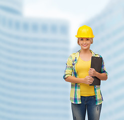 Image showing smiling woman in helmet with clipboard