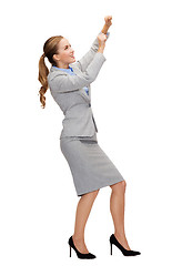 Image showing smiling businesswoman pulling imaginary rope