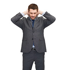 Image showing annoyed businessman covering ears with his hands