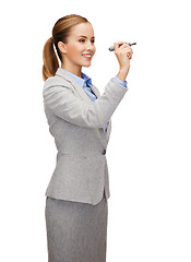 Image showing businesswoman writing something in air with marker