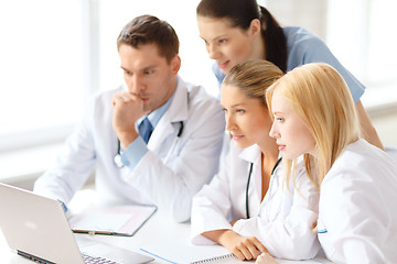 Image showing busy group of doctors looking at laptop computer