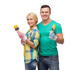 Image showing smiling couple with paintbrush