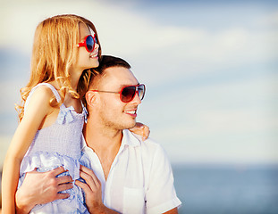 Image showing happy father and child in sunglasses over blue sky