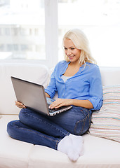 Image showing smiling woman with laptop computer at home