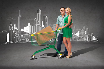 Image showing smiling couple with shopping cart and big box