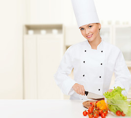 Image showing smiling female chef chopping vagetables