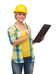 Image showing smiling woman in helmet with clipboard