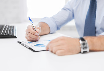 Image showing businessman working and signing papers