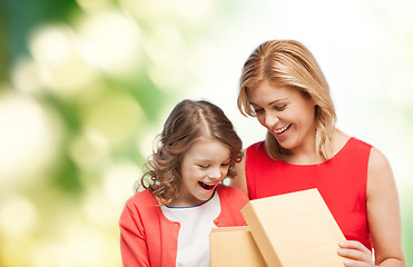 Image showing smiling mother and daughter opening gift box