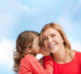 Image showing smiling mother and daughter whispering gossip