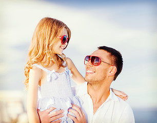 Image showing happy father and child in sunglasses over blue sky