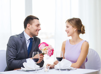 Image showing smiling man giving flower bouquet at restaurant