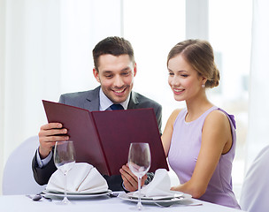 Image showing smiling couple with menu at restaurant