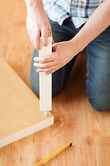 Image showing close up of male hands assemblying legs to table