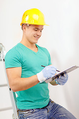 Image showing smiling man in protective helmet with clipboard