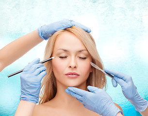 Image showing woman and beautician hands with pencil and scalpel