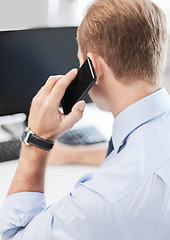 Image showing businessman with smartphone in office